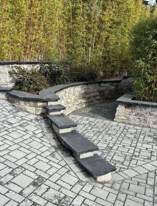 Paver patio with curved retaining wall and bamboo screen in Oak Harbor