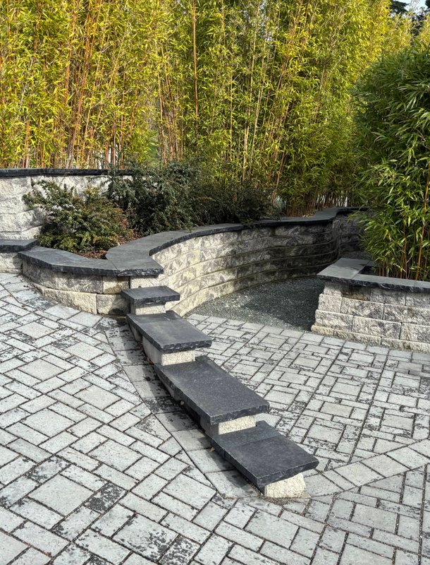Paver patio and curved retaining wall with bamboo screening in Oak Harbor