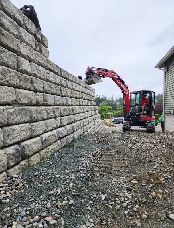 Crew installing a tiered block retaining wall on Whidbey Island